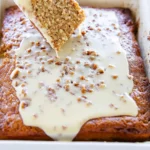 Warm Southern Pecan Praline Poke Cake being drizzled with rich praline glaze.